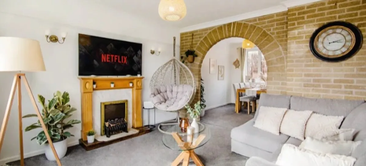 The living room of a Gold Key Property serviced accommodation home, with a brick archway, fireplace and hanging egg chair