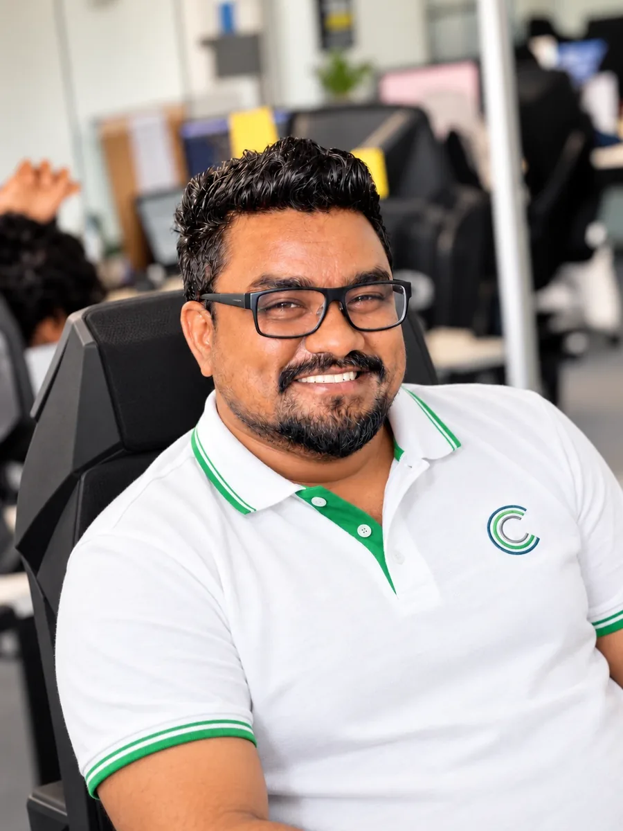 A smiling team member in an Umbrella Connect polo shirt in the office