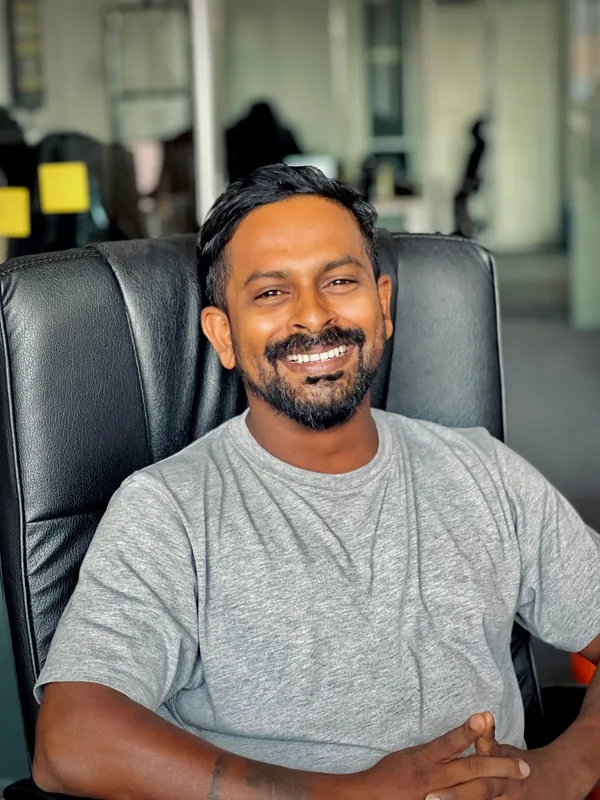 A smiling team member in a grey T-shirt in the office