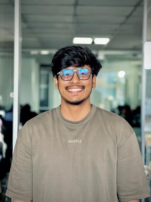 A smiling team member in a Hustle T-shirt in the office