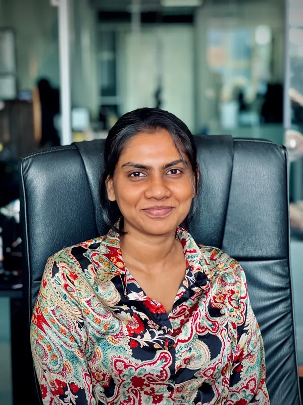 A team member in a patterned shirt smiling in the office