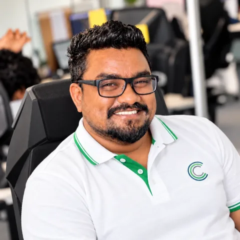 A smiling team member in an Umbrella Connect polo shirt in the office